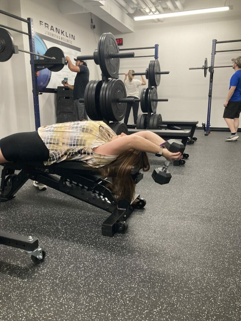 Woman lifting weights overhead at an angle